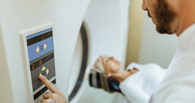 Clinician operating a CT scanner console